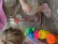 Zwei Kinder beugen sich über verschiedene bunte Behälter und sortieren nasse unterschiedlich farbige Pompons zu den farblich passenden Gefäßen.