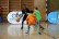 Ein Spieler der Düsseldorfer Basketballmannschaft 'Giants' dribbelt den Ball. Zwei Schüler der Grundschule versuchen ihn zu decken. Die Schüler laufen auf den Spieler zu.