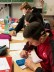 Zwei Schüler und eine Schülerin sitzen über Arbeitsblätter und Taschenrechner gebeugt und arbeiten konzentriert.