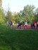 Auf dem Foto sieht man einen Schüler, wie er grade eine Kugel stößt. Vor ihm ist eine große grüne Wiese, hinter ihm sind mehere Schülerinnen und Schüler auf dem roten Sportplatz. Sie schauen zu. 