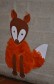Ein Fuchs aus Tonpappe. Als Fell ist rot-braune Filzwolle aufgeklebt. Hinter dem Fuchs sieht man die Wand des Kindergartenflures. 