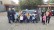Auf dem Bild stehen 16 Kinder 4 Lehrerinnen und 2 Polizistinnen vor einem Streifenwagen. 2 Kinder werden von 2 Lehrerinnen auf dem Arm gehalten.
