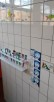 Jedes Kind hat Platz für seine eigene Zahnbürste in einer Halterung an der Wand. Daneben hängt eine Bildanleitung mit dem Titel „KAI putzt richtig“.