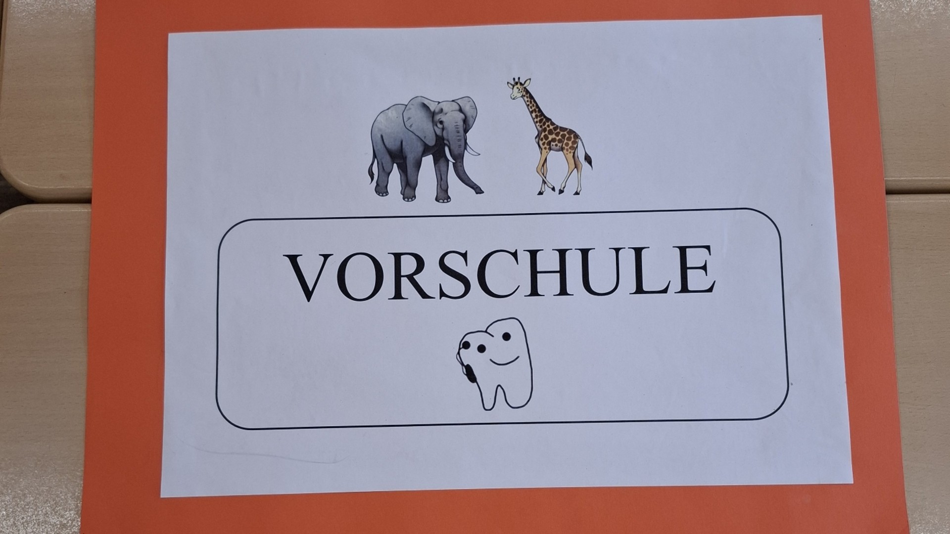 Ein heller Gruppenraum mit Holzboden, auf dem grüne Matten mit gelben Zahlen von 0 bis 20 in einer großen Spirale ausgelegt sind, um spielerisch den Zahlenraum zu erkunden